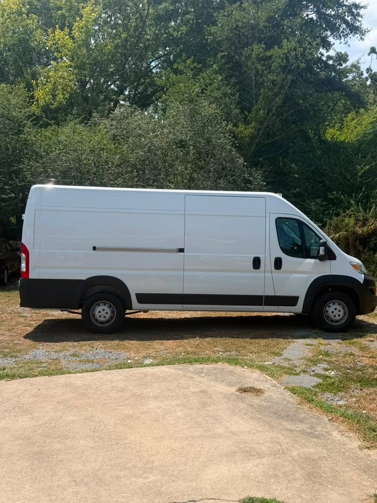 Passenger side exterior of the white Ram ProMaster 3500 High Roof cargo van